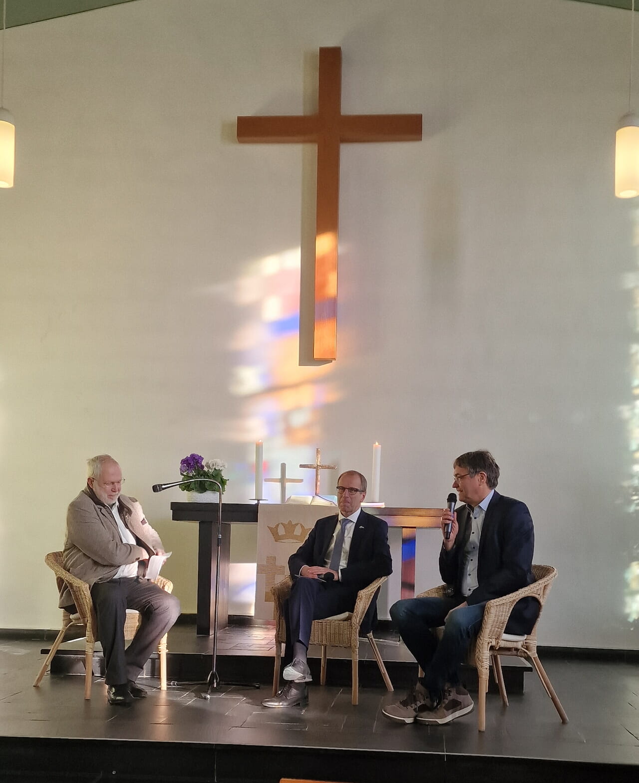 Im von der Sonne erleuchteten Kirchraum erreichte das Gespräch von Peter Liese und Christoph Bartsch eine aufmerksame Gemeinde. Moderator Rainer Müller setzte mit seinen Fragen spannende Akzente. Foto: Kathrin Koppe-Bäumer