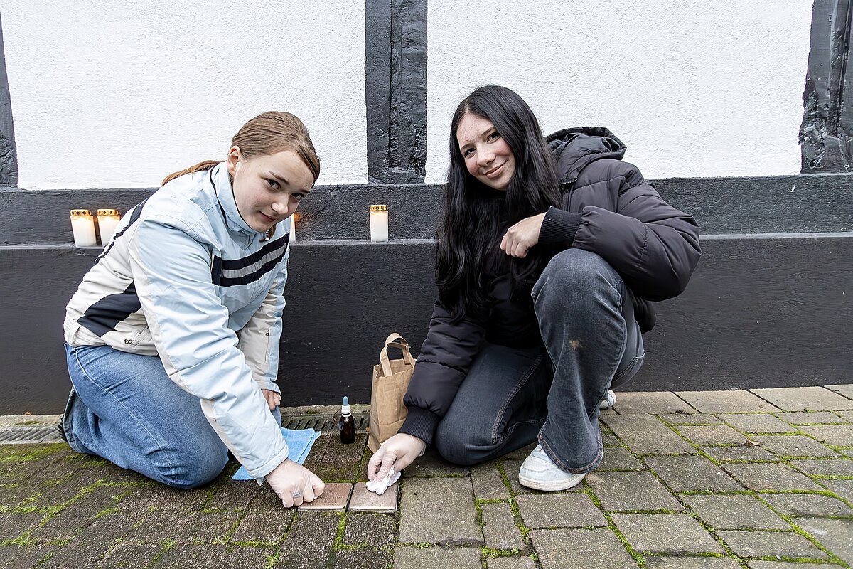 Georgina (links) und Paula von der Möhneseeschule putzen die Stolpersteine für Meyer gen. Max und Henriette Meyerhoff. Fotos: Thomas Brüggestraße