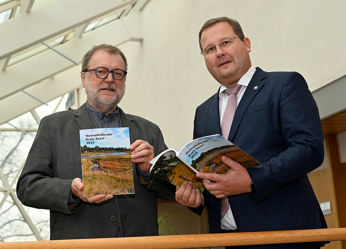 Redakteur Norbert Dodt (links) und Dezernent Sascha Kudella präsentieren den druckfrisch erschienenen Heimatkalender Kreis Soest 2025. Foto: Kira Hönicke